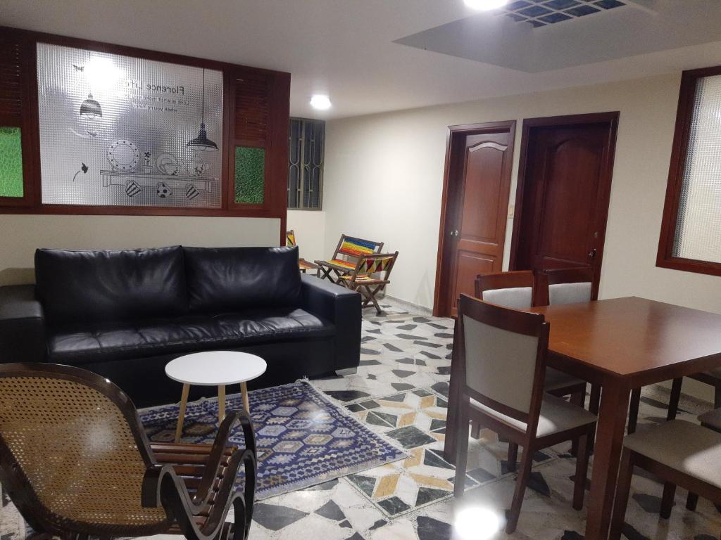 sala de estar con sofá, mesa y sillas en Apartamento Katie urbano, en Paipa