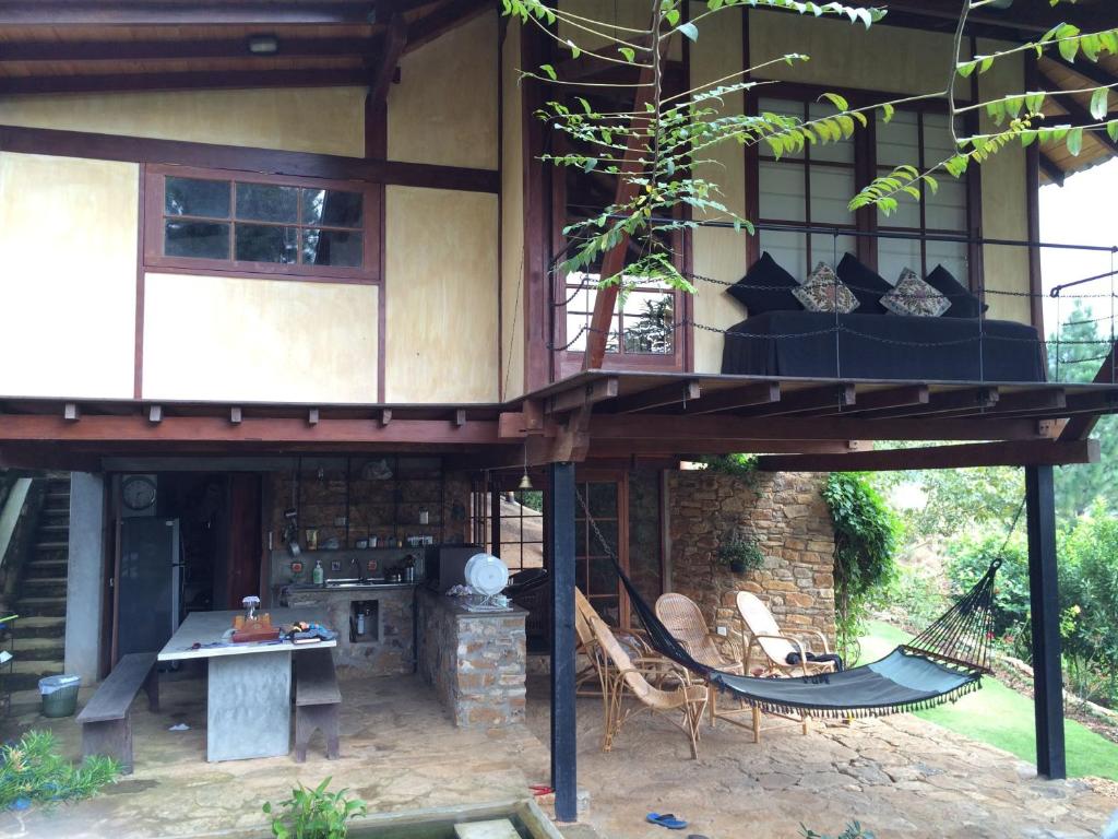 a house with a porch with a hammock in front of it at Lands End Kandy in Kandy