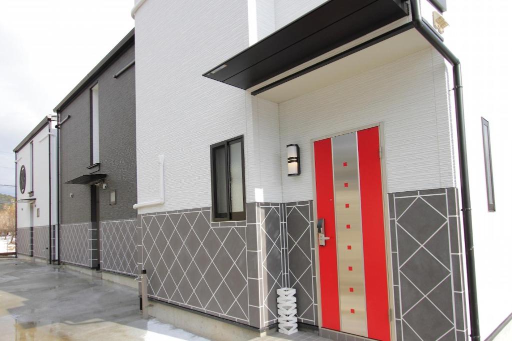 un gran edificio blanco con una puerta roja en Fujinokura Village A - Vacation STAY 84886, en Fujikawaguchiko