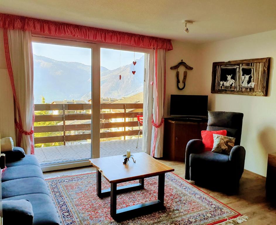 ein Wohnzimmer mit einem blauen Sofa und einem Couchtisch in der Unterkunft Elfe-apartments Studio for 2-4 guests with balcony and panorama view in Emmetten