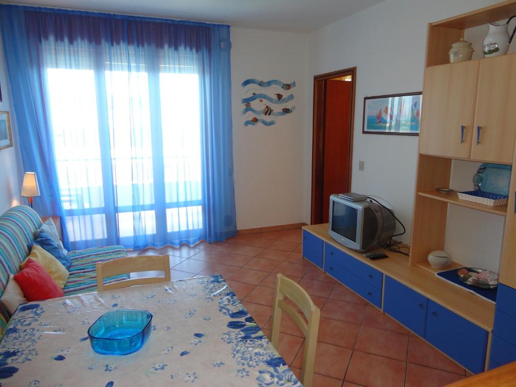 salon ze stołem i telewizorem w obiekcie Your relaxing seaside getaway w mieście Porto Santa Margherita di Caorle