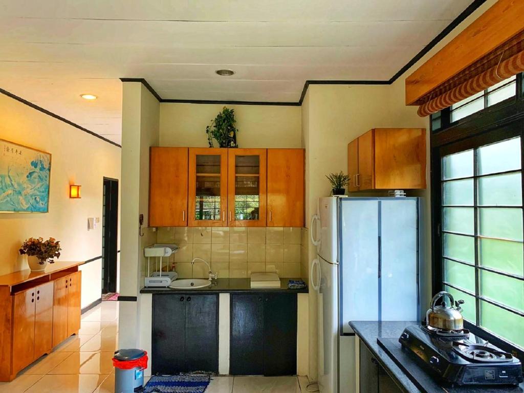 a kitchen with wooden cabinets and a refrigerator at Designer Villa Osaka in Puncak