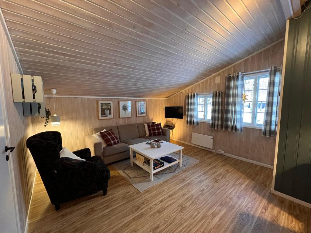 ein Wohnzimmer mit einem Sofa und einem Tisch in der Unterkunft Vennebo - Koselig liten hytte med alle fasiliteter in Ål