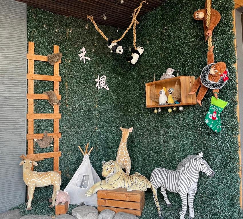 un montón de animales de peluche en una pared verde en Her Home Spa Motel Douliu en Douliu
