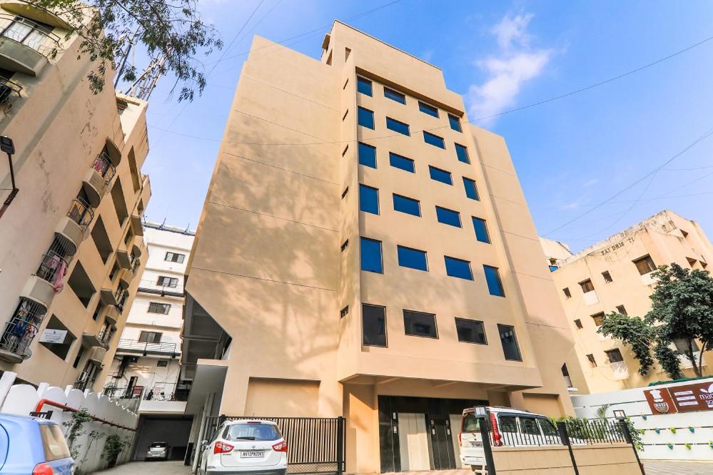 un edificio alto con un cubo como fachada en Magnus Square Business Hotel en Pune