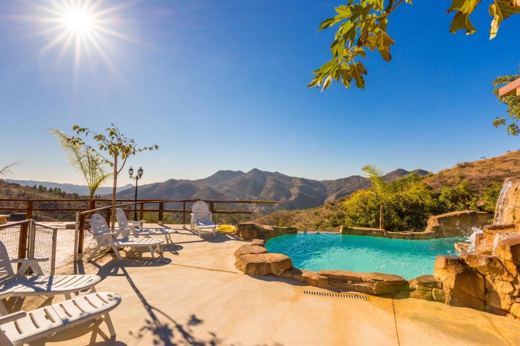 a pool with chairs and a view of the mountains at Casa Miramar in Almogía