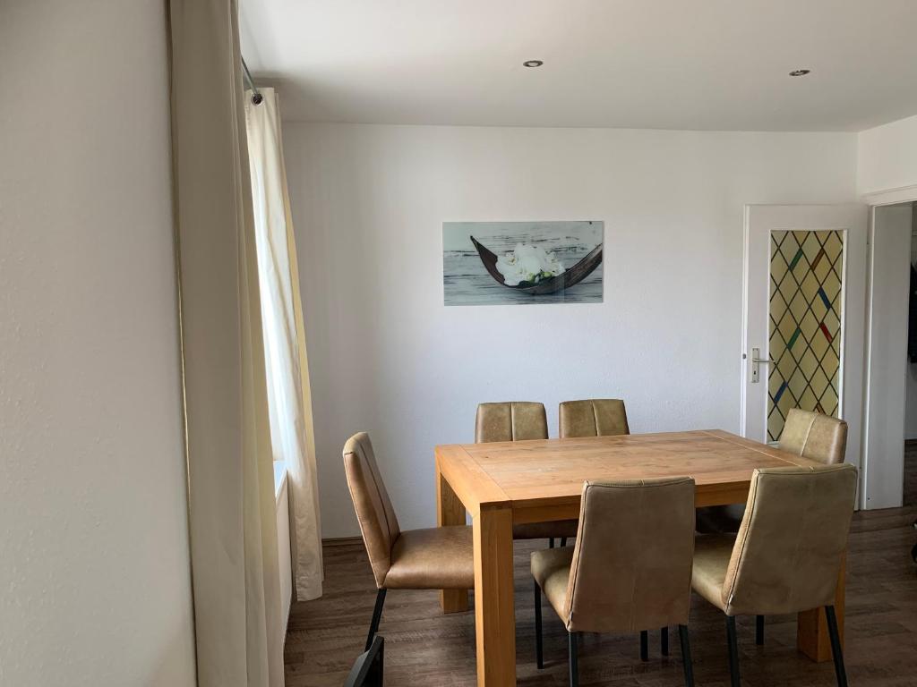 a dining room with a wooden table and chairs at Dorstener Ferienwohnung in Dorsten