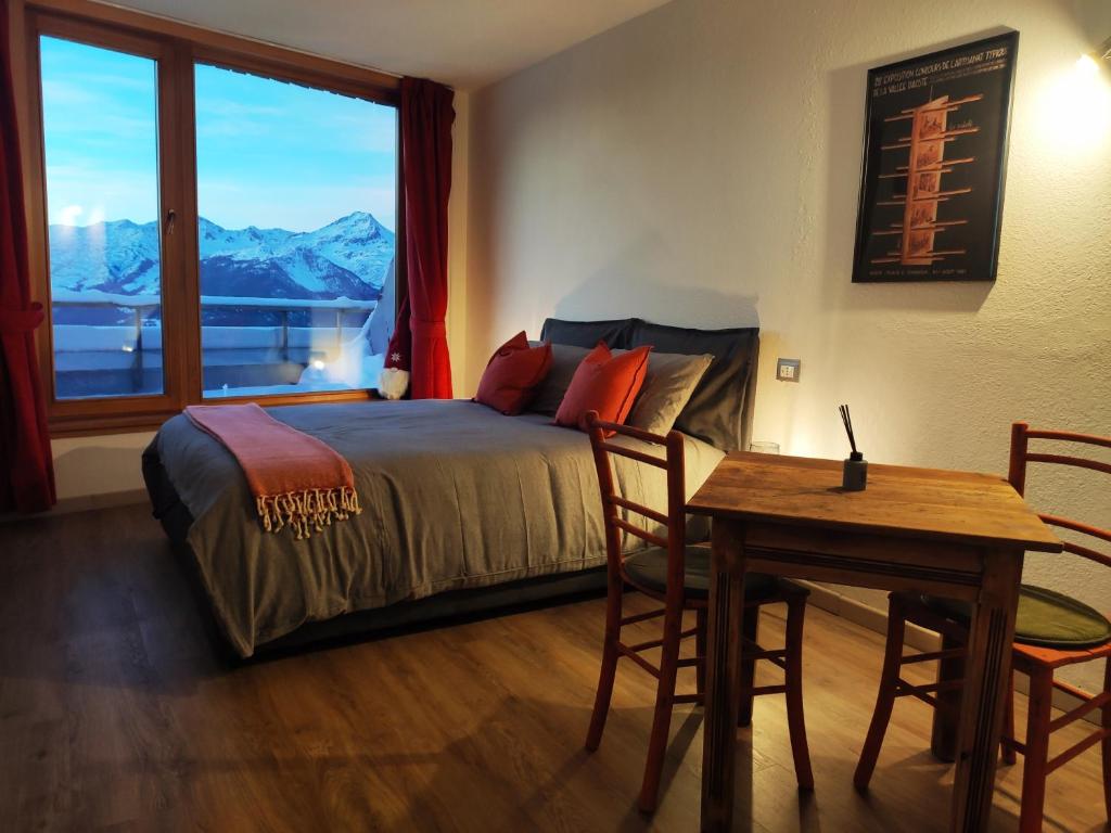 a bedroom with a bed and a table and a window at Studiò Pila 1800 in Pila