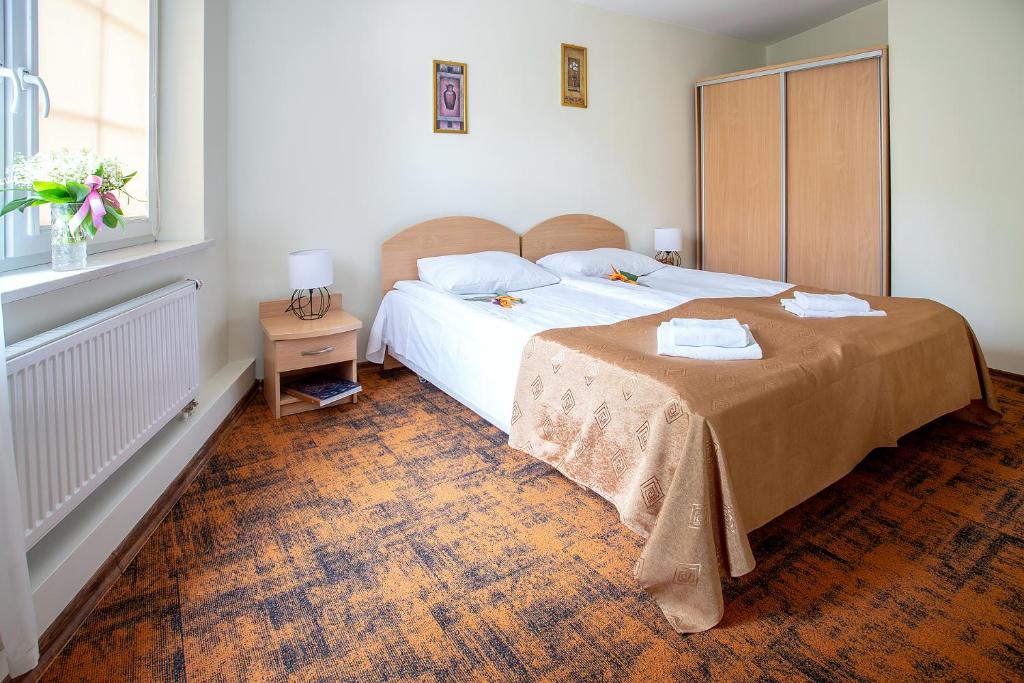 a bedroom with a large bed and a window at Hotel Zamek in Giżycko