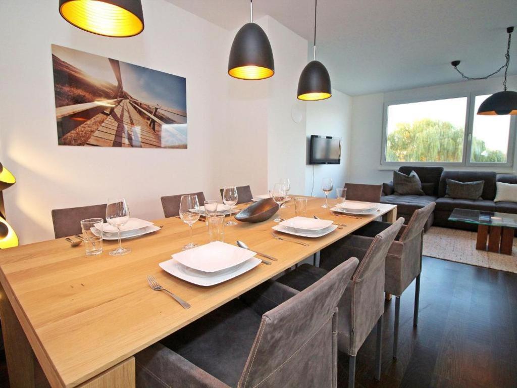 uma sala de jantar com uma grande mesa de madeira e cadeiras em Ferienwohnung Donaublick em Tulln