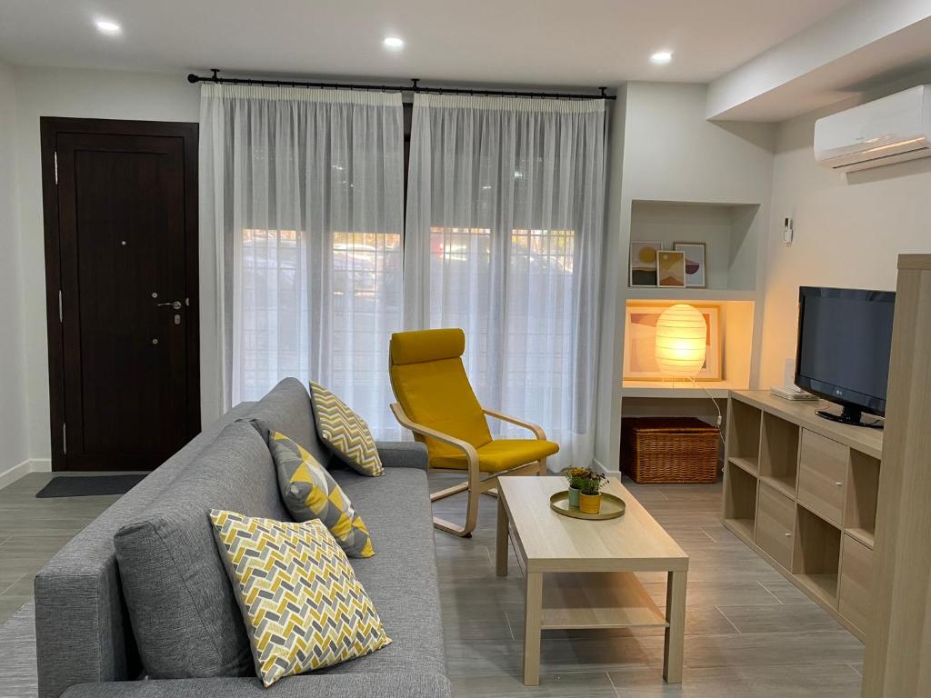 a living room with a gray couch and a yellow chair at Loft céntrico 1 Córdoba in Córdoba