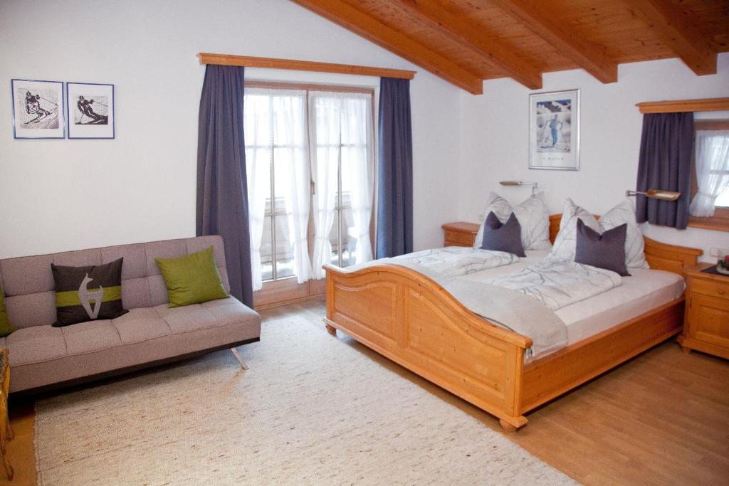 ein Schlafzimmer mit einem Bett und einem Sofa in der Unterkunft Egger Studio Hornblick in Reith bei Kitzbühel