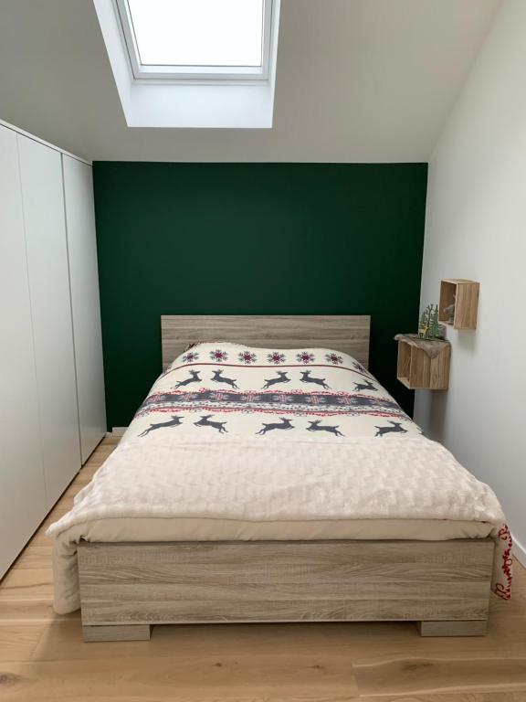 - une chambre dotée d'un lit avec un mur vert dans l'établissement Villa Le Brame, à Ciney
