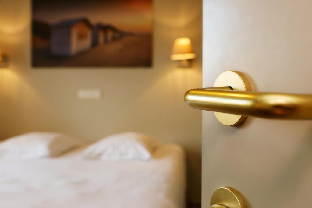 Postel nebo postele na pokoji v ubytování Hotel Les Dunes