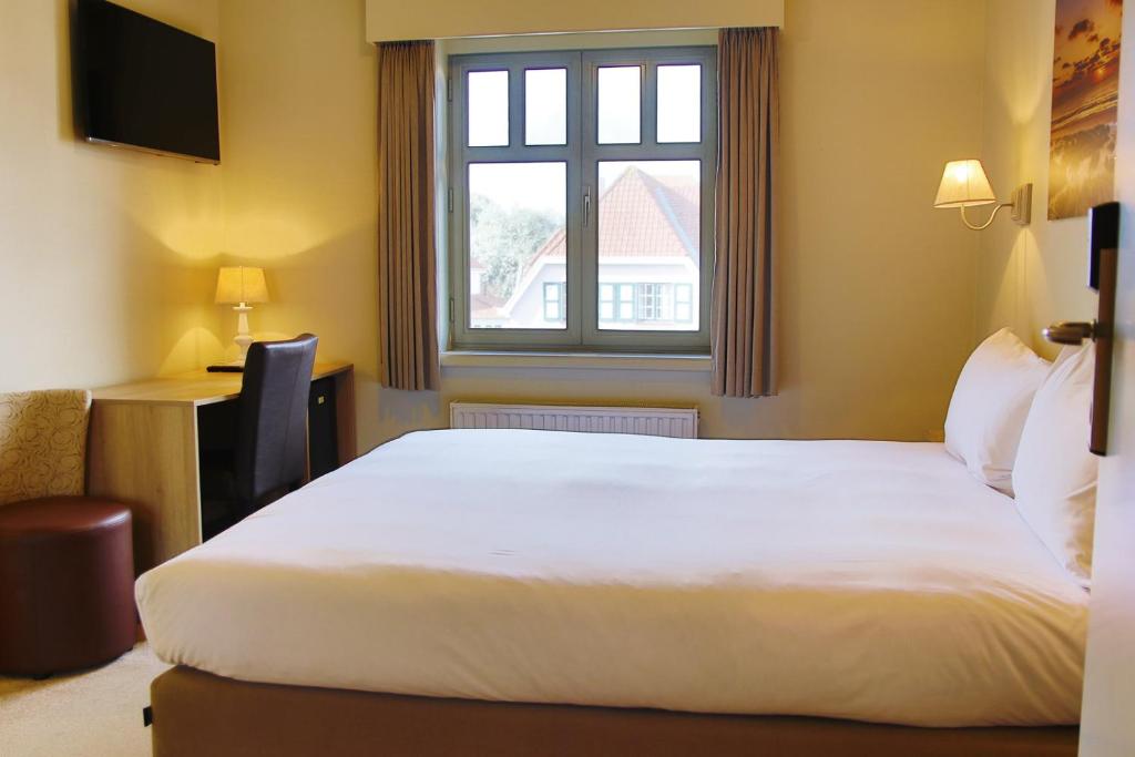 Postel nebo postele na pokoji v ubytování Hotel Les Dunes