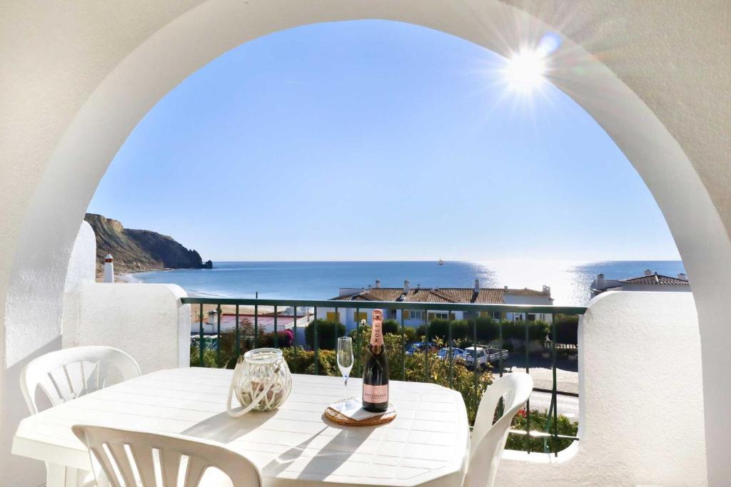 a white table with a bottle of wine on a balcony at 3B Waterside in Luz