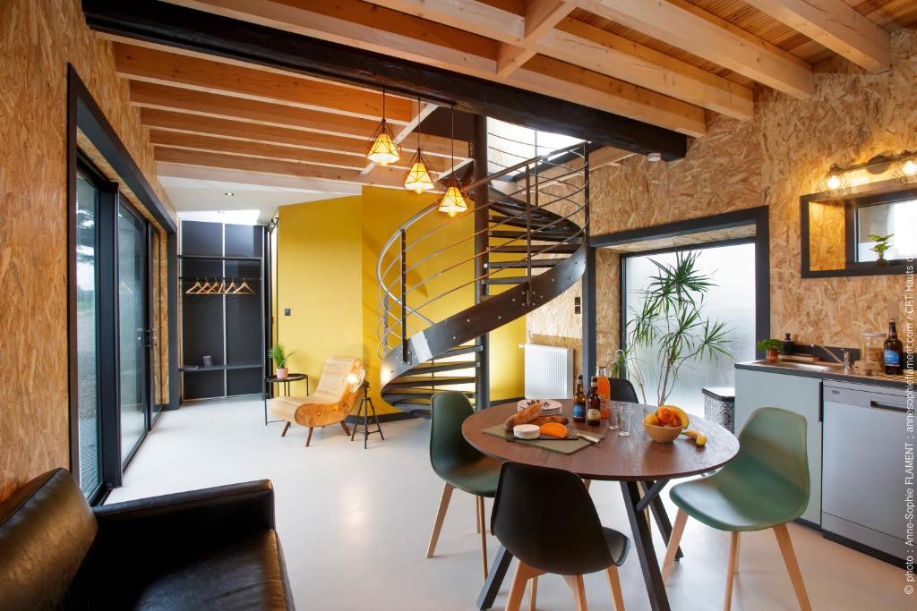 a kitchen and dining room with a spiral staircase at Alex Factory Gites et Chambres d'hôtes Côte d'Opale in Wierre-Effroy