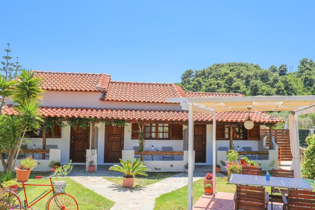 una casa con una mesa y una bicicleta delante de ella en Villa Amy, en Achladies