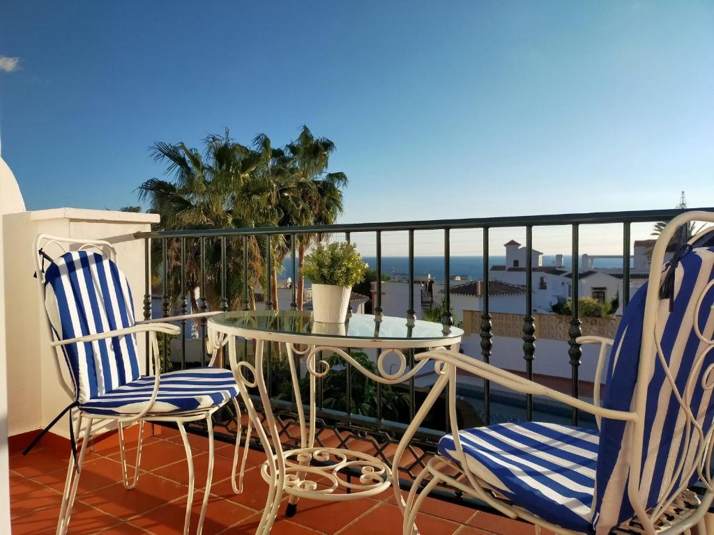 balkon ze stołem i krzesłami oraz oceanem w obiekcie Nerja Sun Apartments Casa Cipreses 9 w mieście Nerja