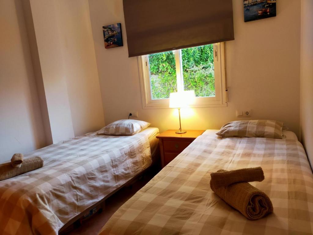 dwa łóżka siedzące obok siebie w sypialni w obiekcie Nerja Sun Apartments Casa Cipreses 9 w mieście Nerja