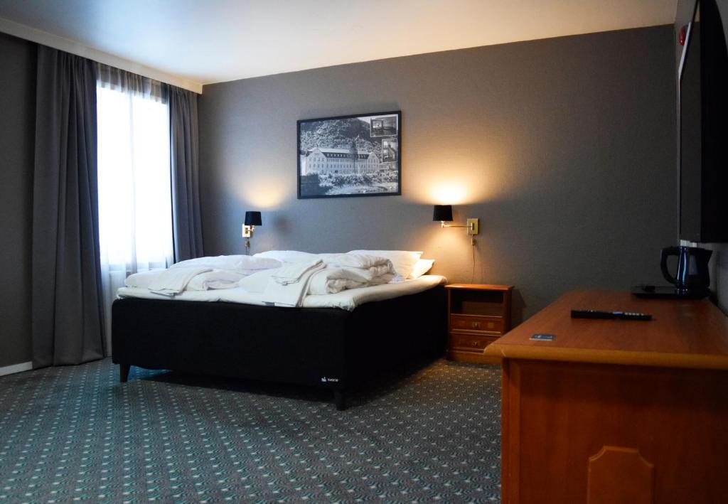 Pokój hotelowy z łóżkiem i biurkiem w obiekcie Rjukan hotell w mieście Rjukan