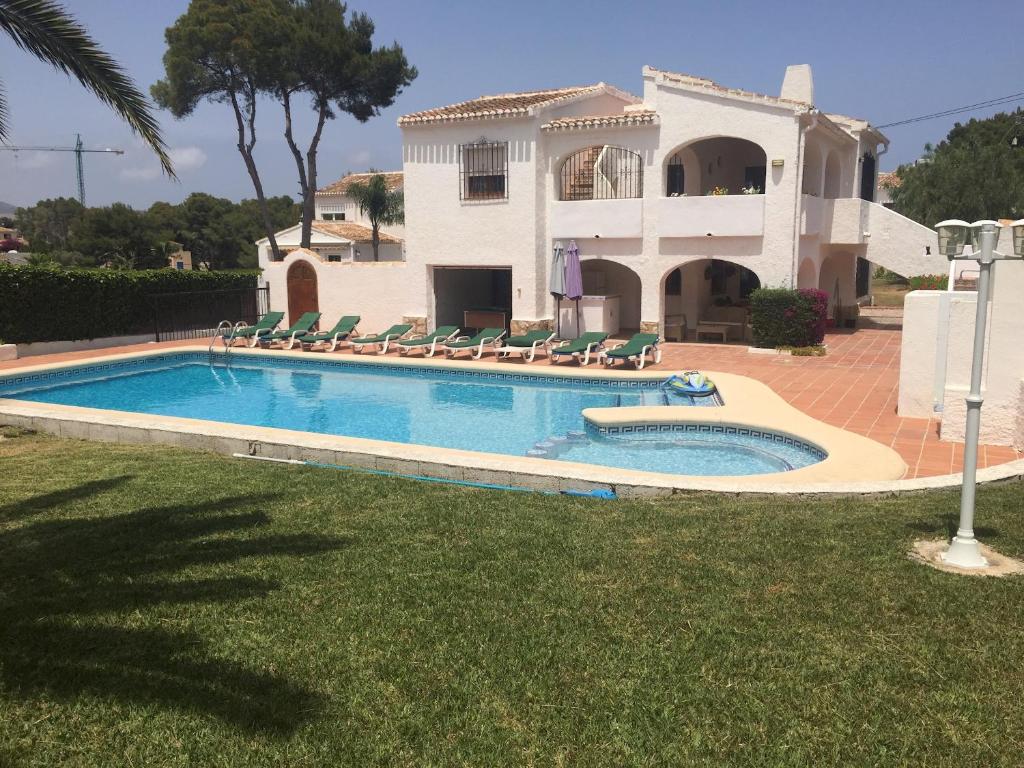uma casa com piscina em frente a uma casa em Villa Simon em Xàbia