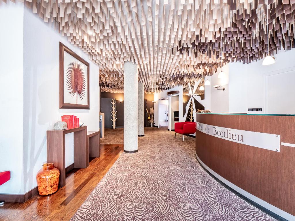 a lobby with a reception area with a chandelier at Hôtel de Bonlieu in Annecy