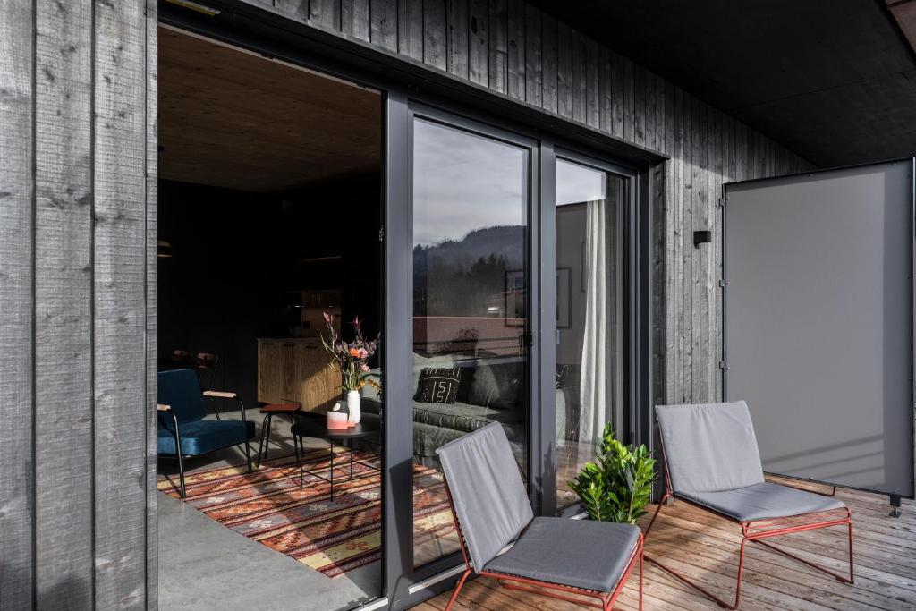 un patio con 2 sillas y una puerta corredera de cristal en Pförtner Penthouse, en Hausham