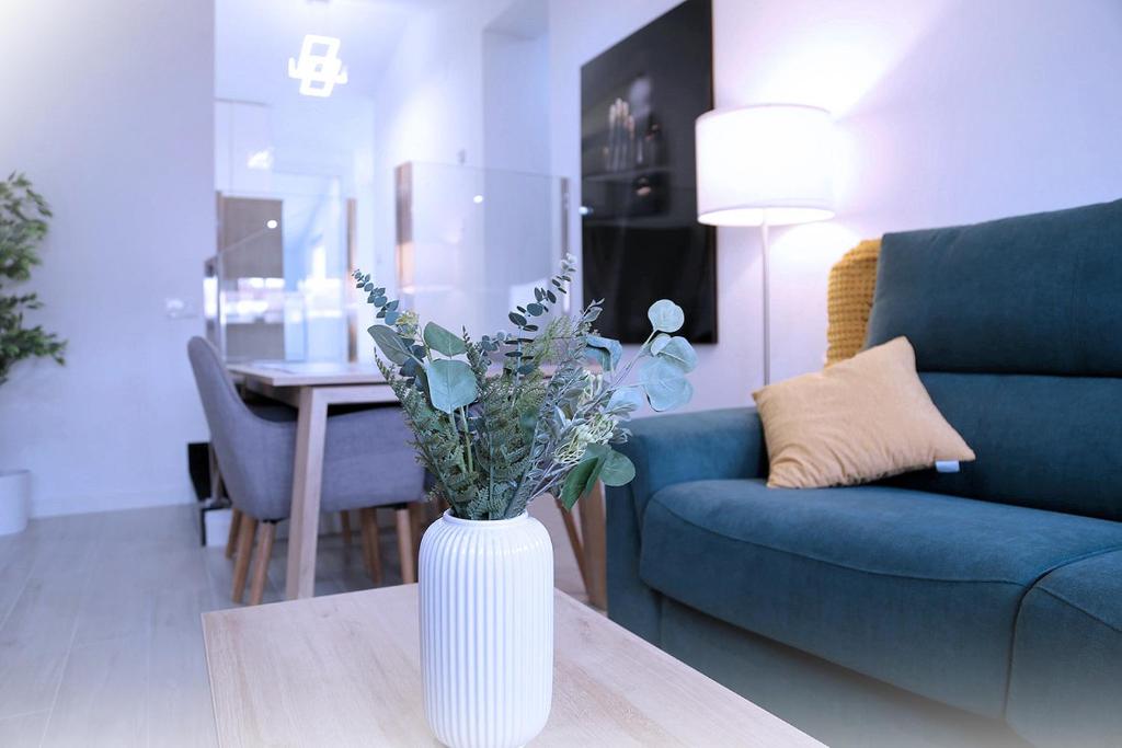 een witte vaas met bloemen op een tafel in een woonkamer bij Ático Plaza Mercado 4,5 in Salamanca