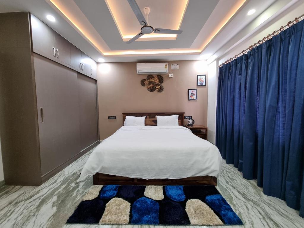 a bedroom with a bed and a blue curtain at The Urban Nest in Bangalore