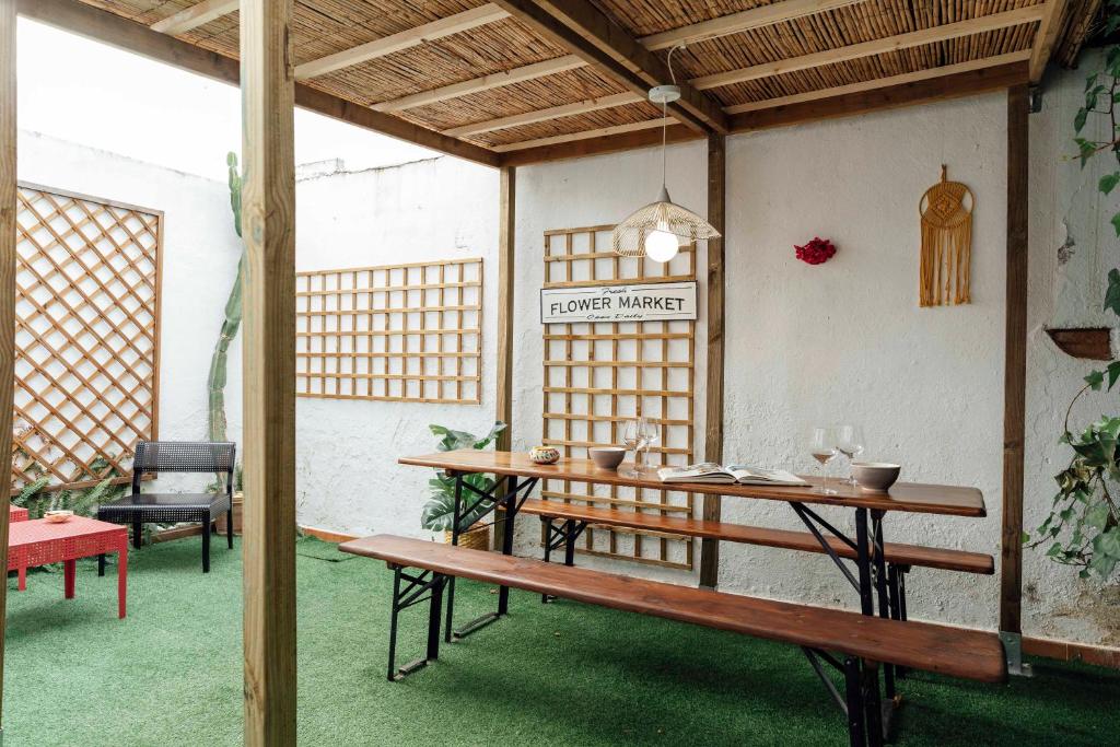 ein Esszimmer mit einem Tisch und einer Bank in der Unterkunft Alohamundi San Basilio in Sevilla