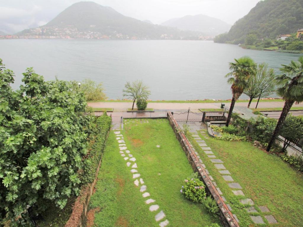 a garden with a view of a lake at Apartment Lungolago by Interhome in Lavena Ponte Tresa