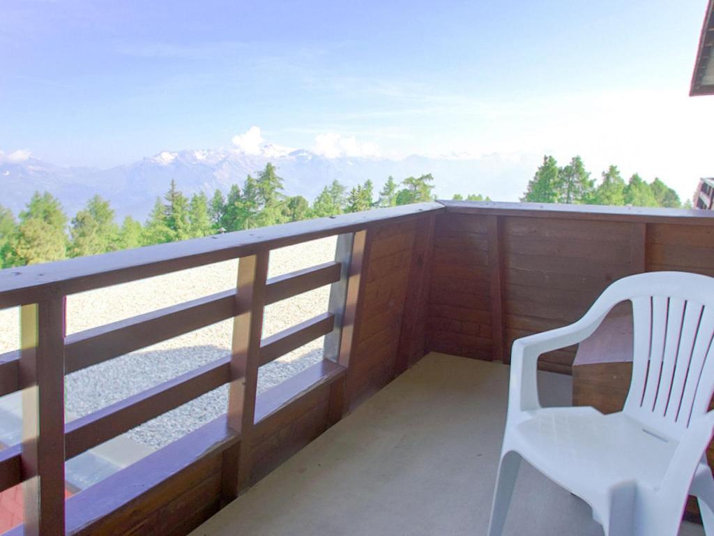 a white chair sitting on a balcony with a view at Studio Résidence Velan-2 by Interhome in Les Collons