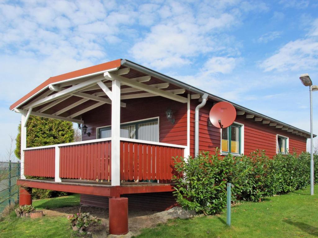 ein rotes Haus mit einer großen Veranda in der Unterkunft Holiday Home Erzeberg-3 by Interhome in Balhorn