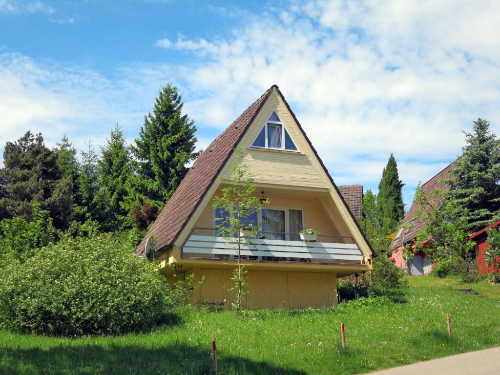 Holiday Home Ferienhäusle Nina by Interhome في Wilhelmsdorf: منزل أصفر صغير بسقف مقامر