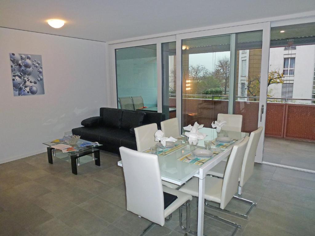 een woonkamer met een glazen tafel en een bank bij Apartment Bletilla by Interhome in Locarno