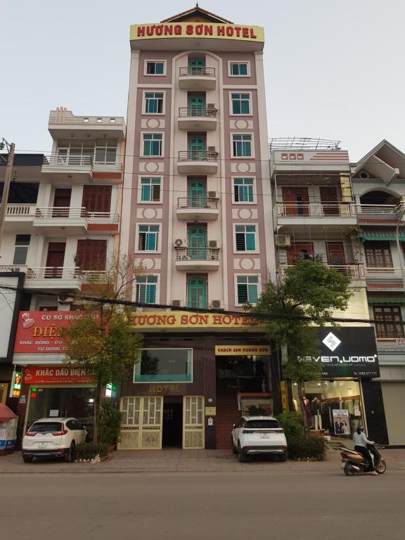 duży budynek z samochodami zaparkowanymi przed nim w obiekcie Khách Sạn Hương Sơn w mieście Bắc Giang