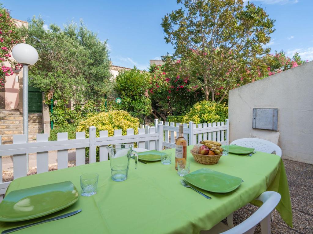 a green table with a bowl of fruit on it at Apartment Les Mas de la Garrigue I et II-1 by Interhome in Cap d'Agde
