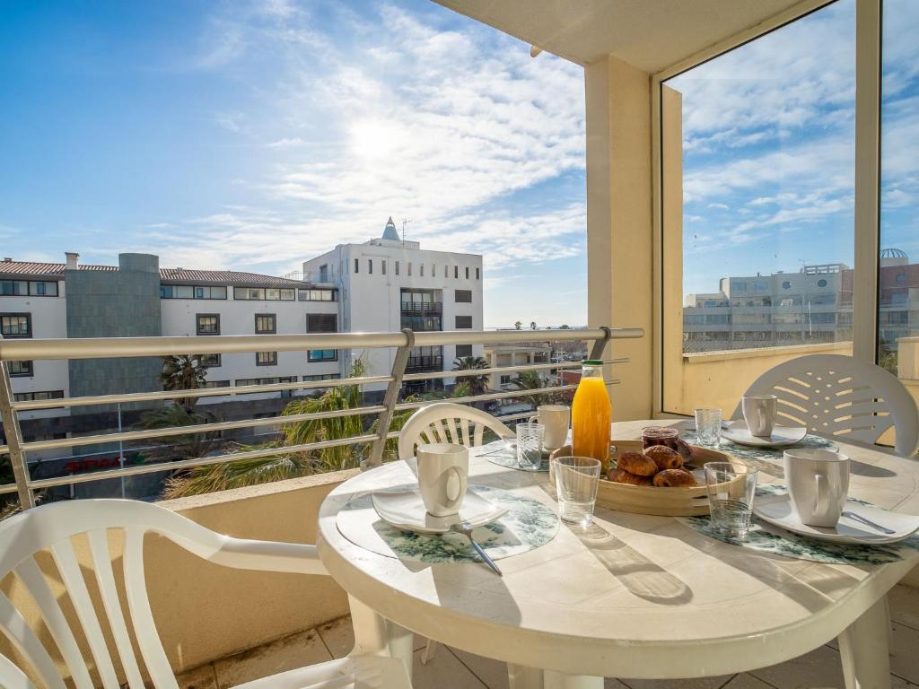 une table blanche et des chaises sur un balcon avec vue dans l'établissement Apartment La Palme d'Or-5 by Interhome, au Cap d'Agde