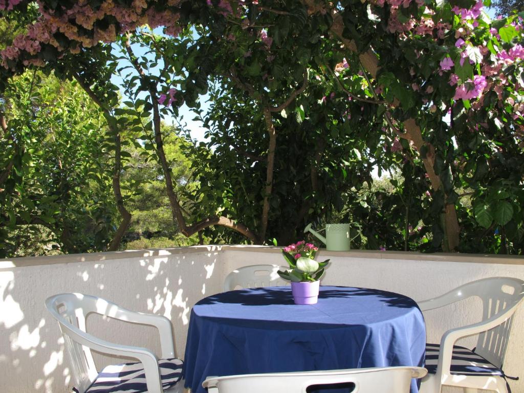 einen blauen Tisch mit Stühlen und eine Vase mit Blumen darauf in der Unterkunft Apartment Lila by Interhome in Mirce