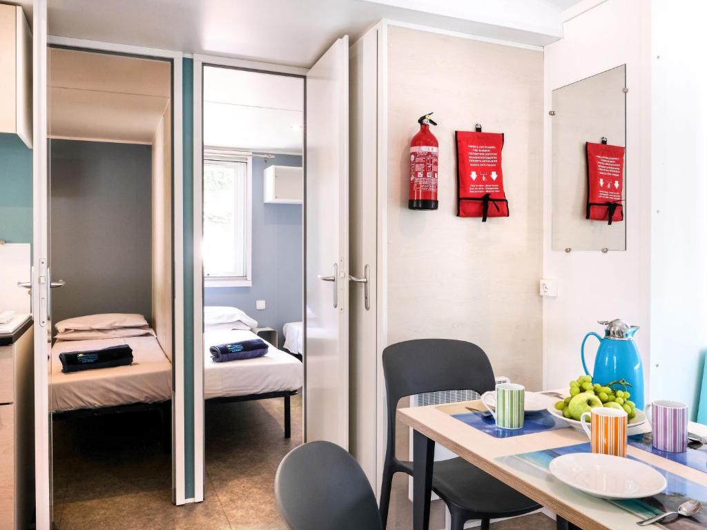 mały pokój ze stołem i łóżkiem w obiekcie Holiday Home Camping Butterfly-2 by Interhome w mieście Peschiera del Garda