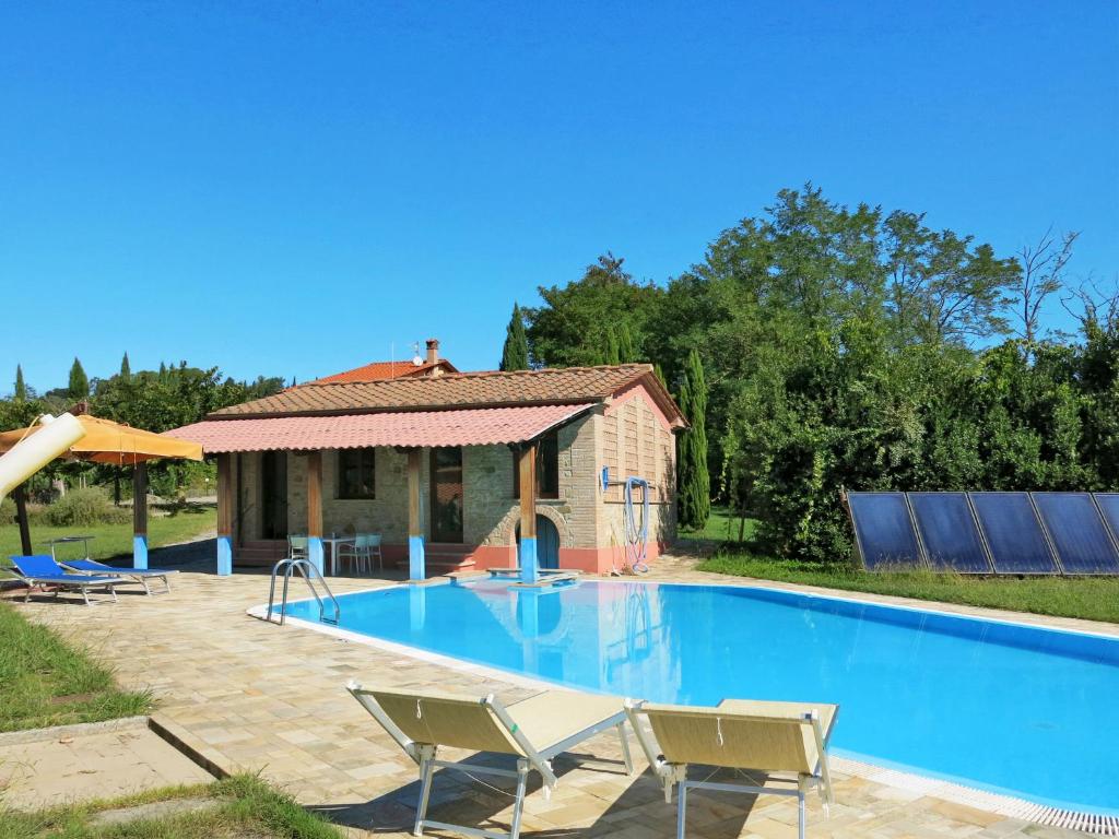 a swimming pool with chairs and a house at Apartment Le Palaie - 'Padronale' - PEC209 by Interhome in Montecchio