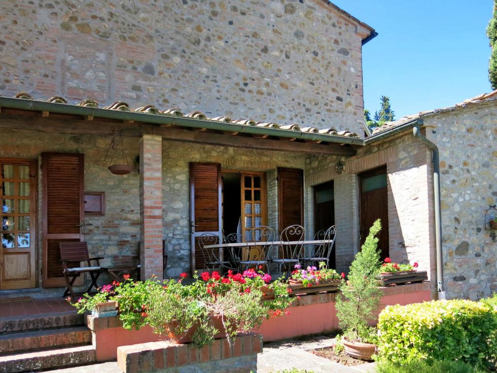 stary kamienny dom z kwiatami na ganku w obiekcie Holiday Home Castagni I - Castagni II by Interhome w mieście Orciatico