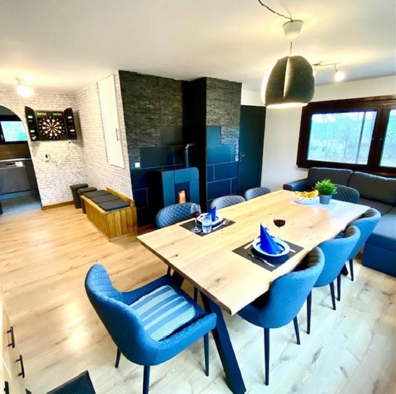 a dining room with a wooden table and blue chairs at Ferienwohnung Vogel in Selbitz