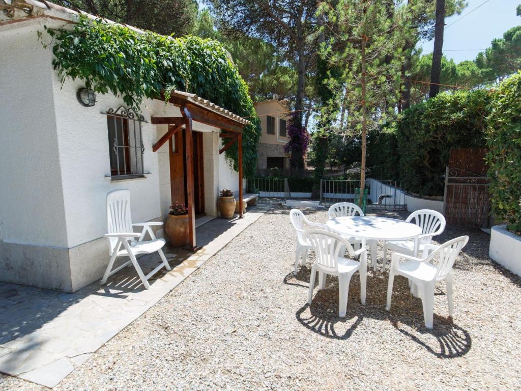 ベグールにあるHoliday Home Calsina Baix by Interhomeの白い椅子とテーブル付きのパティオ、家