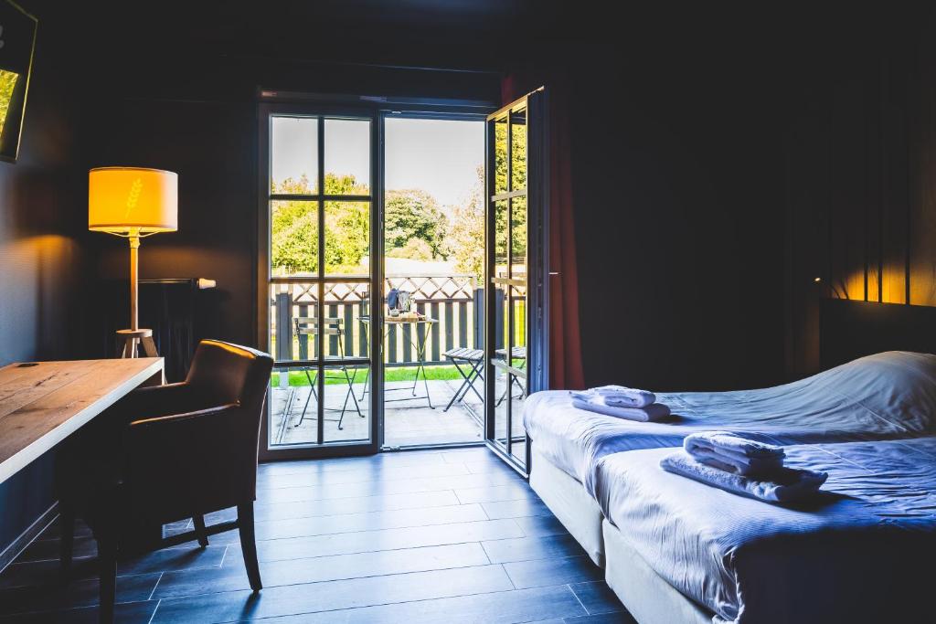een slaapkamer met een bureau, een bed, een tafel en een raam bij Domaine du Blé in Waver