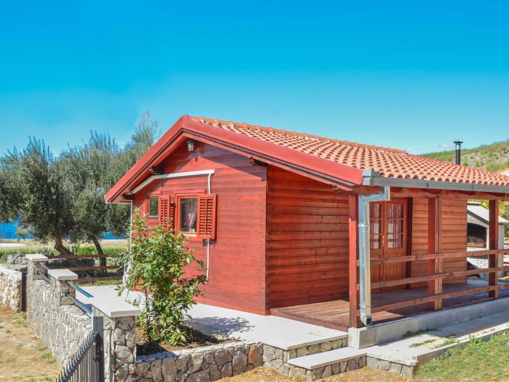 Cette petite maison en bois est dotée d'un mur en pierre. dans l'établissement Holiday Home Palma-5 by Interhome, à Anić