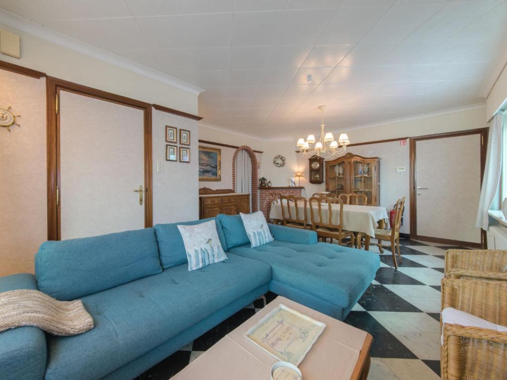 salon z niebieską kanapą i jadalnią w obiekcie Holiday Home Villa Martinella by Interhome w mieście De Haan