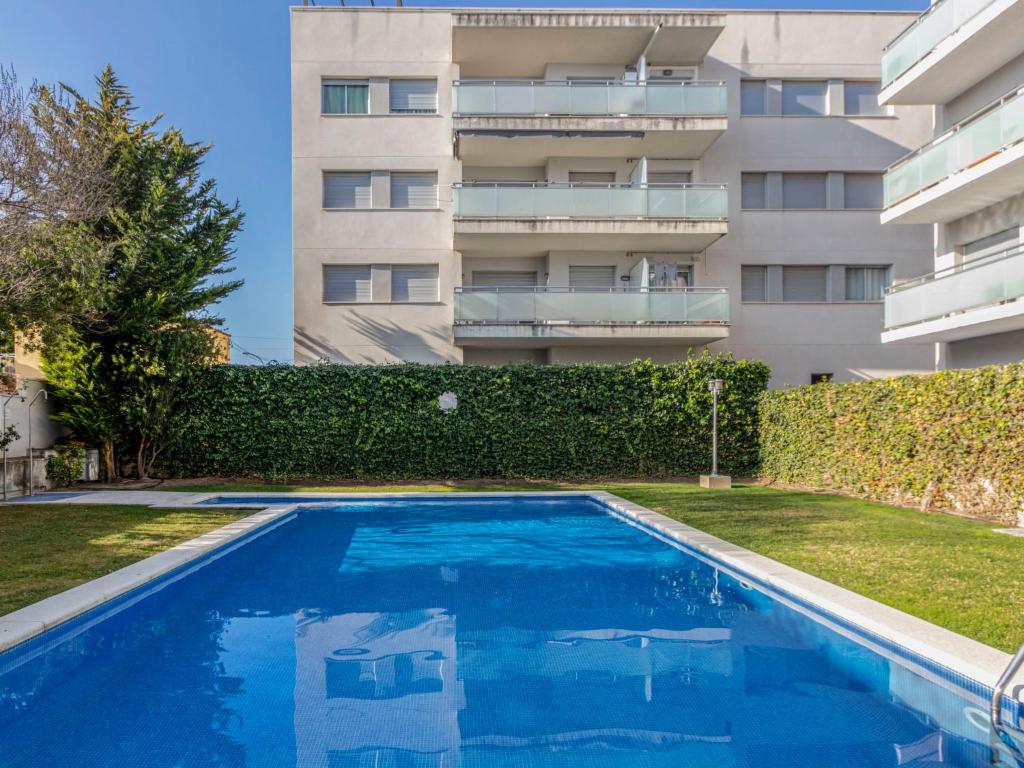 a swimming pool in front of a building at Apartment Oliveres by Interhome in Torredembarra