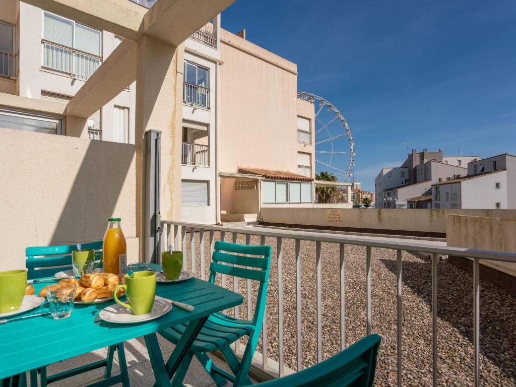 einen Tisch und Stühle auf einem Balkon mit einem Riesenrad in der Unterkunft Studio Quai d'Honneur-2 by Interhome in Cap d'Agde